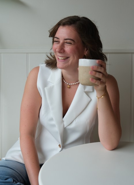 Britt, eine unserer reisenden Familienassistentinnen, lächelnd bei einer Tasse Kaffee